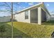 A screened lanai is featured on the back of this home with a fenced backyard and lush green lawn at 3930 Palazzo Pl, Winter Haven, FL 33884