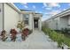 Front entrance with walkway, red flowering Hibiscus, and landscaped garden at 3930 Palazzo Pl, Winter Haven, FL 33884