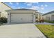 View of the garage, driveway, and front lawn with landscaping at 3930 Palazzo Pl, Winter Haven, FL 33884