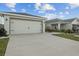 A wide two car garage with driveway and lush landscaping at 3930 Palazzo Pl, Winter Haven, FL 33884