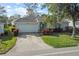 Inviting home exterior showcasing a well-maintained lawn, mature trees, and a convenient two-car garage at 4086 Kingsley St, Clermont, FL 34711