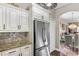 Kitchen features stainless steel refrigerator, white cabinetry, and an open layout to the living space at 4086 Kingsley St, Clermont, FL 34711