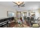 Elegant living room with a piano, wing-style ceiling fan, and dark wood floors at 4086 Kingsley St, Clermont, FL 34711