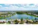 Beautiful aerial view of a home with a serene lake in the background and lush green trees at 446 Davinci Pass, Poinciana, FL 34759