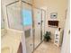 Elegant bathroom showcasing glass shower, neutral tile, a vanity with sink, and linen closet at 446 Davinci Pass, Poinciana, FL 34759