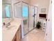 Lovely bathroom boasts glass shower, vanity with sink, white cabinets and tile floors at 446 Davinci Pass, Poinciana, FL 34759