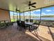 Spacious screened patio featuring ceiling fans, outdoor dining set, and serene water view at 446 Davinci Pass, Poinciana, FL 34759