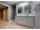 Modern bathroom featuring double sinks with a vanity and a large mirror, complemented by wood-look flooring at 4805 1St Nw St, Lakeland, FL 33810