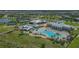 An aerial view of a large community pool, lounge chairs, clubhouse and tennis courts at 4911 Drawdy Ct, St Cloud, FL 34772