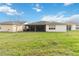 Backyard view of the home highlighting the screened-in patio and grassy area at 4911 Drawdy Ct, St Cloud, FL 34772