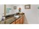 Bathroom vanity featuring a granite countertop, under-sink cabinets, and decorative art at 4911 Drawdy Ct, St Cloud, FL 34772