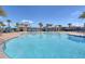 A large community pool with lounge chairs and covered seating areas under a clear blue sky at 4911 Drawdy Ct, St Cloud, FL 34772