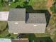 An aerial view of the roof and backyard of the home, surrounded by green grass and greenery at 4941 Luna Negra Dr, Orlando, FL 32811