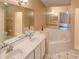 Well-lit bathroom with double vanity sinks, a soaking tub, and a separate glass-enclosed shower at 4941 Luna Negra Dr, Orlando, FL 32811