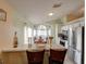 Well-lit dining area featuring a chandelier, large window, and a view into the kitchen at 4941 Luna Negra Dr, Orlando, FL 32811