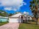 Charming single-story home featuring a two-car garage and a well-maintained lawn with palm trees at 4941 Luna Negra Dr, Orlando, FL 32811