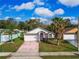 Charming single-story home with a two-car garage, front lawn and a lovely palm tree in the front yard at 4941 Luna Negra Dr, Orlando, FL 32811