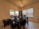 Formal dining area with a dark wood table and chairs, complemented by natural light from windows at 499 Meadow Pointe Dr, Haines City, FL 33844