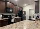 Kitchen with granite countertops and black appliances at 499 Meadow Pointe Dr, Haines City, FL 33844