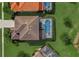 Aerial view of a home featuring a screened pool, patio, and tile roof in a well-manicured neighborhood at 5411 Oakgrain Ct, Davenport, FL 33837