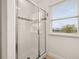 Bright bathroom featuring a glass enclosed shower, tiled walls, and a window providing natural light at 5411 Oakgrain Ct, Davenport, FL 33837