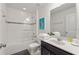 The bright white bathroom offers a walk-in shower with tile surround, framed mirror, and vanity with a clean, modern design at 5411 Oakgrain Ct, Davenport, FL 33837