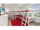 Bright bedroom with a corner bunk bed, red rug, and a window providing natural light at 5411 Oakgrain Ct, Davenport, FL 33837