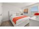 Bedroom featuring a bed with an orange blanket, bright white linens and matching furniture at 5411 Oakgrain Ct, Davenport, FL 33837