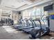 Well-equipped fitness center with treadmills, elliptical, and ample natural light from large windows at 5411 Oakgrain Ct, Davenport, FL 33837