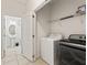 Neat laundry area with modern appliances, shelving, and easy access to an adjacent bathroom at 5411 Oakgrain Ct, Davenport, FL 33837