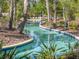 A beautiful lazy river surrounded by trees with clear blue water invites relaxation and fun at the community at 5411 Oakgrain Ct, Davenport, FL 33837