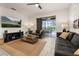 Comfortable living room featuring a neutral color scheme, TV, and sliding door access to the pool at 5411 Oakgrain Ct, Davenport, FL 33837