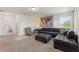 Relax in this room featuring a sectional sofa, ottoman, custom world map art, and neutral carpeting in a calm color palette at 5411 Oakgrain Ct, Davenport, FL 33837