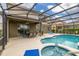 Gorgeous screened pool with spa, seating area, and outdoor dining space for entertaining at 5411 Oakgrain Ct, Davenport, FL 33837