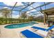 Inviting screened-in pool with lounge chairs, grill and manicured landscaping at 5411 Oakgrain Ct, Davenport, FL 33837