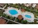 Aerial view showcasing community pools, surrounded by lounge chairs, cabanas, and landscaped gardens at 5578 Metrowest Blvd # 11, Orlando, FL 32811