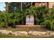 Landscaped entrance to The Palms Club, with a prominent sign surrounded by lush palm trees and decorative rock at 5578 Metrowest Blvd # 11, Orlando, FL 32811