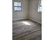 An empty bedroom featuring hardwood floors and natural light from two windows at 5804 Viking Rd, Orlando, FL 32808