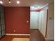 Interior view of a living room featuring dark red walls and hardwood flooring at 6028 Westgate Dr # 104, Orlando, FL 32835