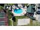 Aerial view of a kidney-shaped pool, hot tub, volleyball court and lounge seating in a landscaped setting at 6028 Westgate Dr # 104, Orlando, FL 32835