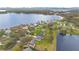 Aerial view of a serene neighborhood featuring a charming house near a large lake at 6301 Oak Shore Dr, St Cloud, FL 34771