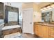 Bathroom featuring stone accents, granite countertops, and a soaking tub at 6301 Oak Shore Dr, St Cloud, FL 34771