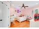 Pink bedroom with hardwood floors, a ceiling fan, and wainscoting at 6301 Oak Shore Dr, St Cloud, FL 34771