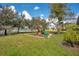 Grassy backyard featuring a playground with swings and slides at 6301 Oak Shore Dr, St Cloud, FL 34771