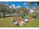 Outdoor playground and fire pit area in a lush green backyard at 6301 Oak Shore Dr, St Cloud, FL 34771