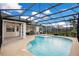 Sparkling screened-in pool with covered seating and a grill at 6301 Oak Shore Dr, St Cloud, FL 34771