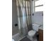 Standard bathroom features a tiled shower and toilet with a light blue patterned shower curtain at 6356 Bennett Ct, St Cloud, FL 34771