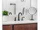 Close-up of bathroom quartz countertop, dark wood vanity, and matte black modern faucet at 6699 Alder Rd, Harmony, FL 34773