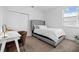 Cozy bedroom featuring tufted headboard, large window, and a bright white walls at 6699 Alder Rd, Harmony, FL 34773