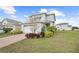 Charming two-story home with a well-manicured lawn, complemented by beautiful landscaping and a colorful front garden at 6699 Alder Rd, Harmony, FL 34773